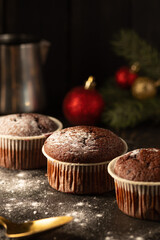 Chocolate muffins with powdered sugar on top on a black background. Christmas decoration . Still life close up. Food photo.