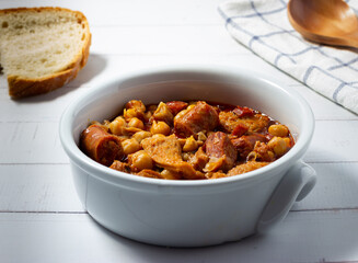  Tripe casserole with chickpeas on a white wooden background. Winter comfort food. (Callos a la madrileña)