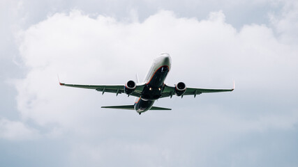Passenger plane comes in for landing in cloudy weather.