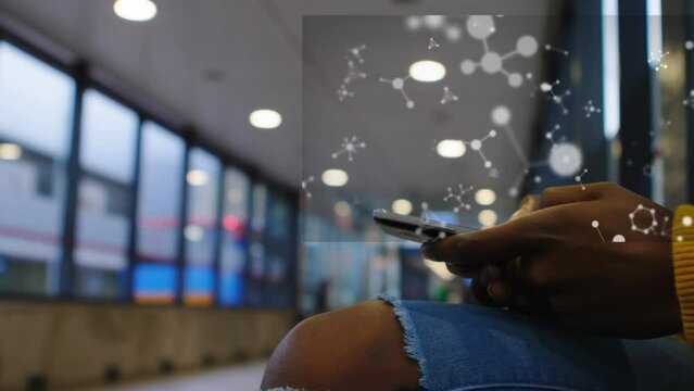 Animation of floating nucleotides over midsection of african american man using cellphone