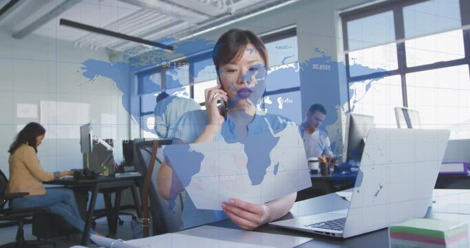 Animation of map with numbers over asian businesswoman discussing report over phone and using laptop