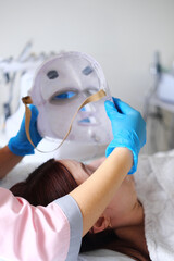 Fototapeta premium Woman getting cosmetic procedure with LED facial mask. , photon therapy