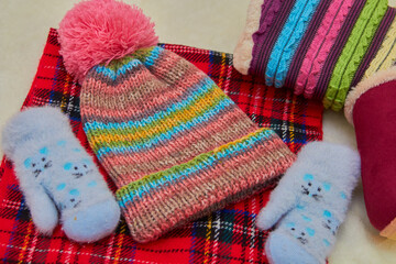 Fototapeta na wymiar winter clothing accessories,knitted colored cap with a scarf and gloves