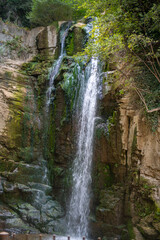Fototapeta na wymiar blue waterfall in Tbilisi green trees and bridge