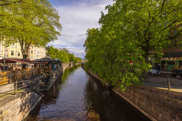 Fototapeta premium Beautiful view of riverfront in Uppsala city center with outdoor restaurants and cafes. Sweden. Europe. Uppsala.