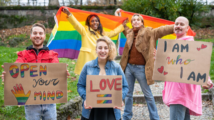 Gay Pride Parade, group of young activist for lgbt rights with rainbow flag and banner, diverse people of gay and lesbian community