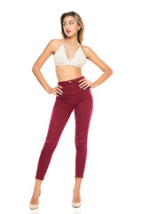 a young woman in burgundy jeans and top, and high heels shoes posing on a white background