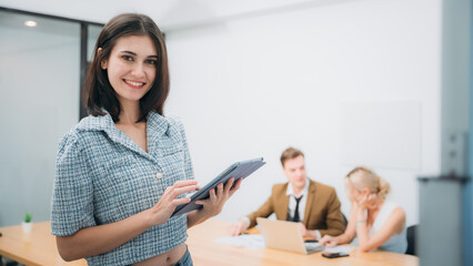 Portrait of happy Business looking camera and people converse during a meeting about papers and...