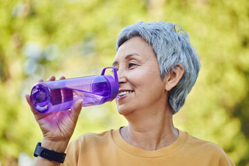 Close up mature woman holds plastic bottle drinking water - 552432701