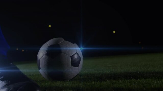 Animation of blue light spot of low section of male soccer player kicking the ball
