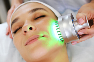 Light infrared therapy. Cosmetology head procedure. Beauty woman face. Cosmetic salon device....