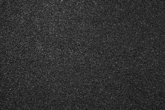 The texture of dense black foam rubber.The background of the foam is black.The substrate is made of black foam rubber.