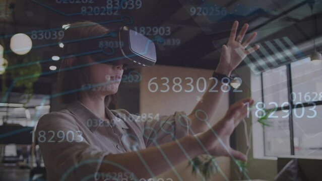 Animation of data processing over caucasian businessman using vr headset at office