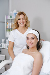 Fototapeta premium Plastic surgery and beauty concept. A professional cosmetologist receives a client in his office. Beautician looking at camera and smiling