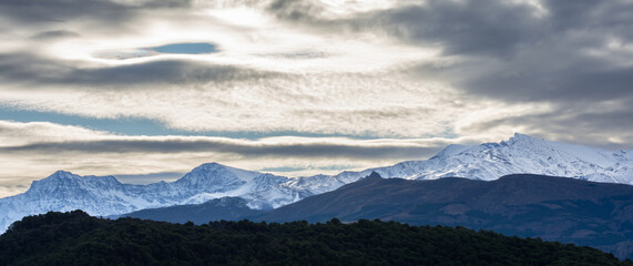 Obraz na płótnie Canvas Beautiful lenticular clouds over the snowy peaks of Sierra Nevada (Granada, Spain)