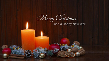 Candles with Christmas decorations in front of a wooden wall and the text Merry Christmas and a Happy New Year.