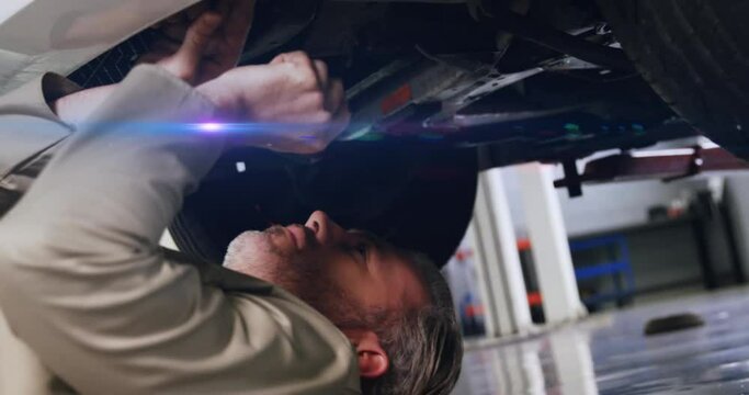 Animation of light trails over caucasian male mechanic reapiring car