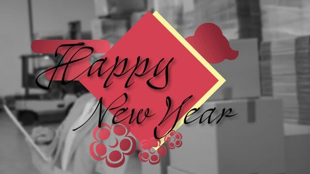Animation of happy new year text over caucasian woman in warehouse