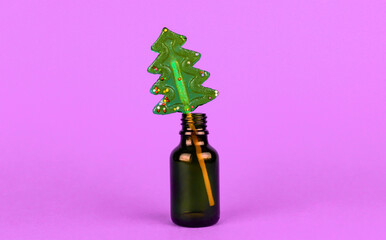 Christmas tree-shaped lollipop in a small glass bottle on a purple background - Powered by Adobe