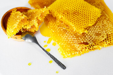 honeycomb on a white background and in a clay plate with a spoon