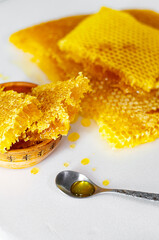 Honeycomb on a white background and in a clay plate with a spoon
