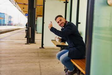 Business man sitting at the train or bus station waiting for his transportation, he's going on vocation