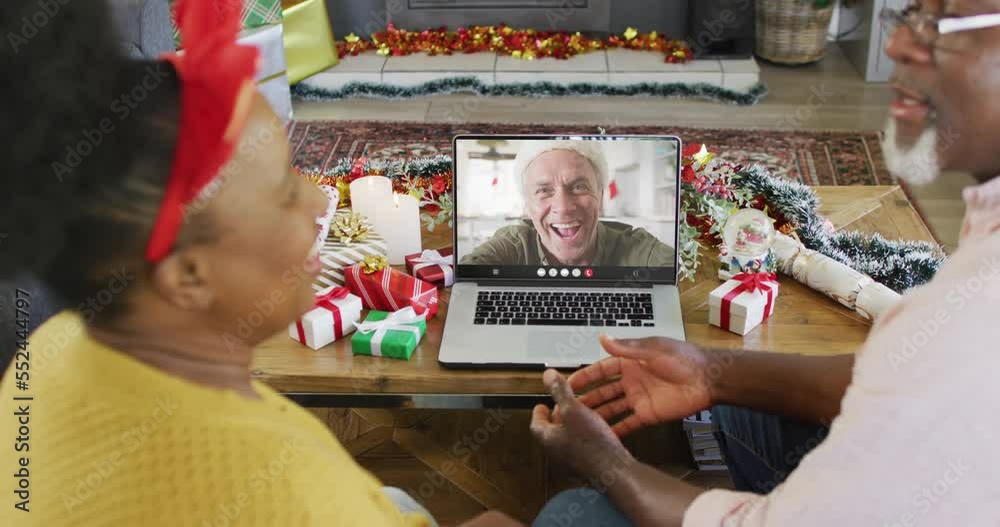 Poster Senior african american couple having christmas laptop video call with happy caucasian man