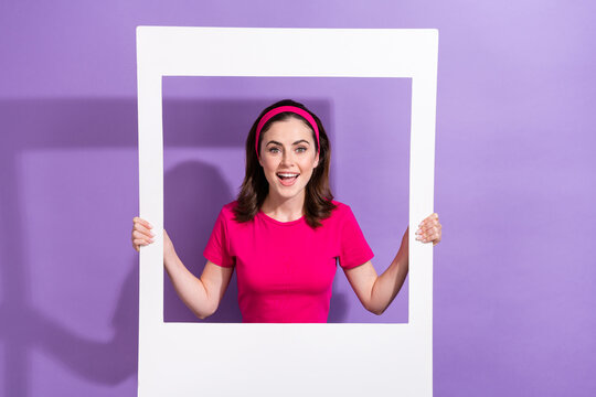 Photo of pretty cheerful person toothy smile hands hold paper album card isolated on violet color background