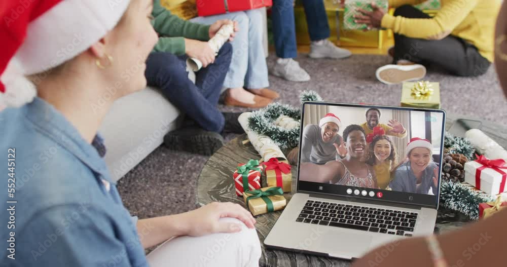 Poster Diverse friends with santa hats having laptop video call with diverse friends