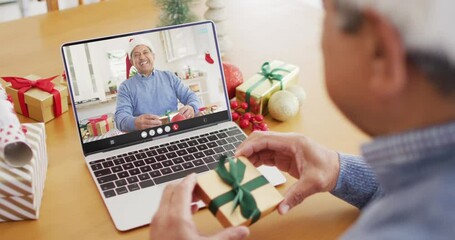 Senior biracial man having christmas video call with senior biracial man - Powered by Adobe