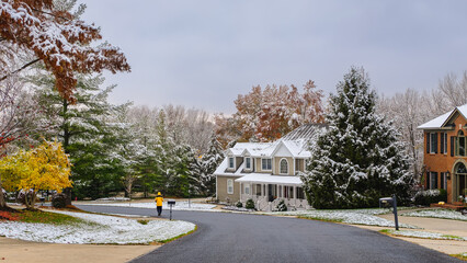 Suburban Midwestern neighborhood after early snow; small figure of walking man at distance - obrazy, fototapety, plakaty