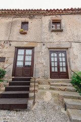Fototapeta na wymiar Dos puertas de madera de diferentes casa de piedras dentro de la muralla del castillo de Vila Vella en Tossa de Mar con aspento muy antiguo dando un toque romántico al paisaje.