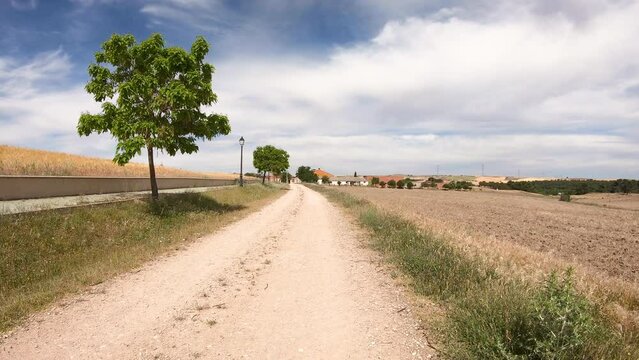 Camino de Madrid - a dirt road on a summer landscape entering A&ntilde;e village, province of Segovia, Castile and Le&oacute;n, Spain