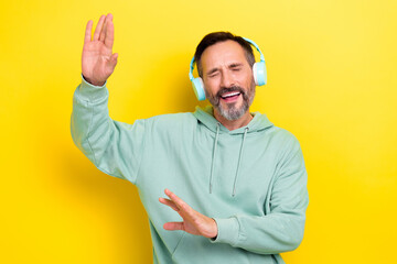 Portrait of satisfied man dressed green hoodie listen favorite music playlist dancing having fun...