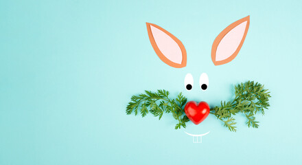 Easter bunny face with a heart shaped nose and whiskers from carrot leaves, holiday greeting card,...