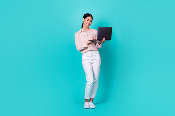 Full size photo of successful indonesian person hold use netbook isolated on vibrant emerald color background