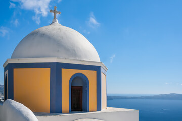 View of a traditional and colourful orthodox church and the Aegean sea in Santorini Greece