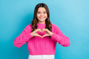 Photo of cute cheerful toothy beaming smile curly brown hair teenager girl showing love heart symbol charity isolated on blue color background