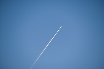 Fondo natural con cielo de color azul y avion en vuelo con estela
