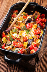 Traditional Greek briam fresh from oven with vegetable, feta and potatoes served as close-up in a ristic casserole