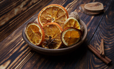 dried orange slices in a plate on a dark wooden table. selective focus. 