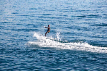 A man rides on an electric surfboard. Surf on an electric board