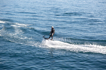 A man rides on an electric surfboard. Surf on an electric board