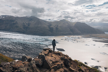 Fototapeta premium A woman with his back turned looking at glacier Skaftafell. Iceland glacier