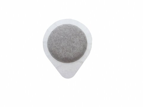 Coffee capsule for Italian espresso machine, close-up, disposable and compostable filter paper - isolated on white background