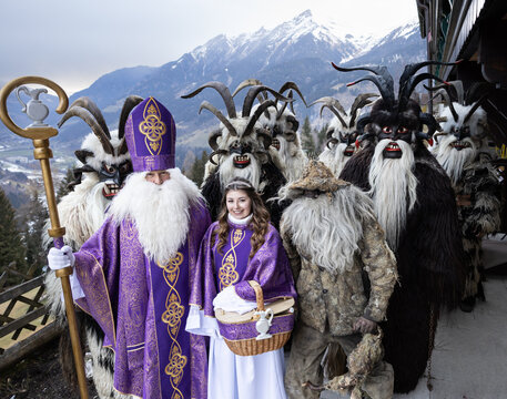 Costumed procession of St. Nicholas, an angel and kramus in a mountainous region, Austria, Salzburg