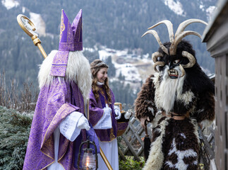 Saint Nicholas, Angel and Krampus prepare for the traditional Christmas procession in the highlands of Austria, Salzburg