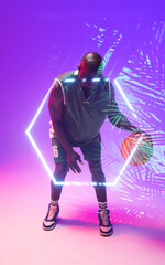 Fototapeta na wymiar African american bald basketball player dribbling ball by illuminated hexagon and plants
