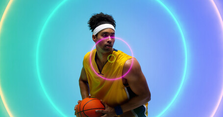 Naklejka premium Composite of biracial male player holding basketball looking away over illuminated circles