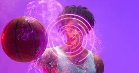 Naklejka premium Composite of illuminated circular and abstract pattern over biracial basketball player holding ball